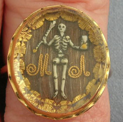 Memento mori ring showing a skeeleton (death) holding an hourglass (time flies) and an arrow. c.1680. Image courtesy of B. Robbins.
