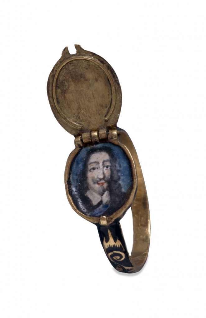 This gold ring has an oval bezel that opens to form a concealed locket, containing an enamelled portrait of Charles I (reigned 1625-49). The hinged lid is set with a diamond on an enamelled ground.  Commemorative jewellery depicting royalty was usually produced after the monarch's death, but was occasionally available during their lifetime, to be worn as a demonstration of loyalty. Commemorative jewellery, in the form of rings, lockets or hair clasps, was produced in great numbers after Charles' execution on 30 January 1649. Many examples have hinged lids: supporters of the Royalist cause, who wished to keep their allegiance secret, probably wore these during the Commonwealth under the rule of Oliver Cromwell. The Restoration of the monarchy in 1660 again produced great numbers of commemorative jewellery, made for those who claimed to have been Royalist supporters all along. Some rings commemorating Charles I were presented during his lifetime by his Queen, Henrietta Maria (1609-69), to Royalist supporters in appreciation of their continuing loyalty and financial backing, to be redeemed when the Civil War had ended.  Much commemorative jewellery is decorated with black enamel in the same fashion as mourning jewellery. The shoulders of this ring have a scroll pattern reserved in gold on a ground of black enamel, the diamond is bordered with black enamel, and the border of the bezel is decorated with a black and white enamelled pattern.  C. Oman, British rings 800-1914 (London, Batsford, 1974)