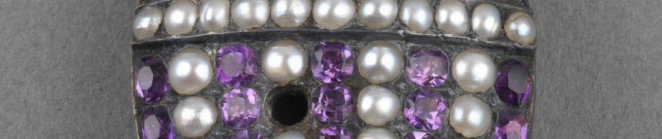 Mourning locket in the form of a funerary urn with seed pearls and amethysts, reverse with lock of hair. Inscribed around edge in gold on white enamel, 'P.ALFRED. BORN 22.SEP 1780 DIED 20 AUG 1782'. Suspension loop.