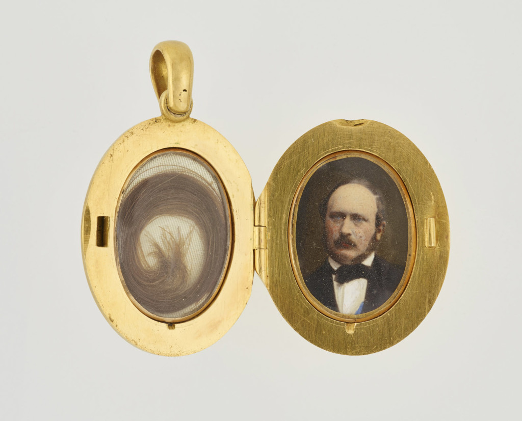 A small gold memorial locket, set with central oval onyx, black on white, with diamond star set in plain gold border with blue enamel inscription, 'Die reine Seele schwingt sich auf zu Gott', roughly translated as 'The pure soul flies up above to the Lord'. Opens to reveal hair on one side and photograph of Prince Albert on the other, both under glass.