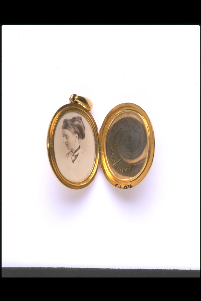 A jeweller made this locket to commemorate someone who had died. The back of it is inscribed 'In remembrance of L.B.F. Oct 7th 1871, from C.G.S.F.'. The widowed husband of the woman in the photograph probably bought the locket and gave it as a keepsake to one of his wife's close friends or relations. Lockets were particularly fashionable items of jewellery from about 1860 to1880 and they have remained popular ever since.