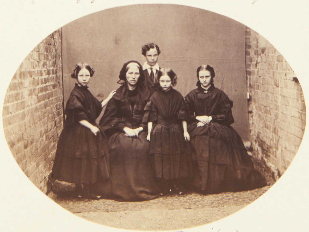 Photograph of a group that includes the children of the Jager McDonald. From left to right: Helena, standing with her left arm on her mother, Mrs McDonald seated; George who stands behind his mother; Caroline standing facing the viewer and Annie (1848-66?) seated facing the viewer. Provenance Acquired by Queen Victoria