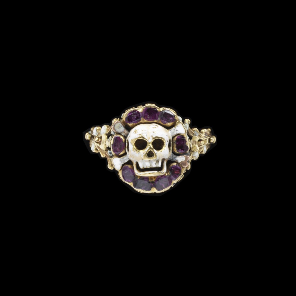 Enamelled gold ring, the bezel in the form of a skull and cross-bones in a border of rubies with an enamelled rosette behind, two marks 'CC' and 'AL[?]' in a monogram. Europe, 1550-75. Image courtesy of the V&A Museum.