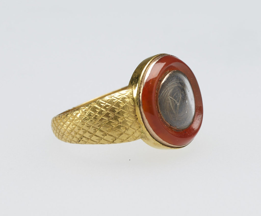 A gold mourning ring chased with diaper pattern. The circular top set with cornelian rim, encircling crystal with hair. Provenance Bequeathed to Princess Elizabeth by her sister Princess Sophia Matilda of Gloucester; on her own death in 1844.