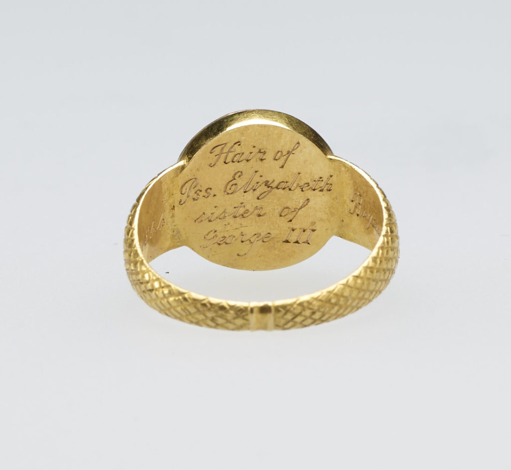 A gold mourning ring chased with diaper pattern. The circular top set with cornelian rim, encircling crystal with hair. Provenance Bequeathed to Princess Elizabeth by her sister Princess Sophia Matilda of Gloucester; on her own death in 1844.