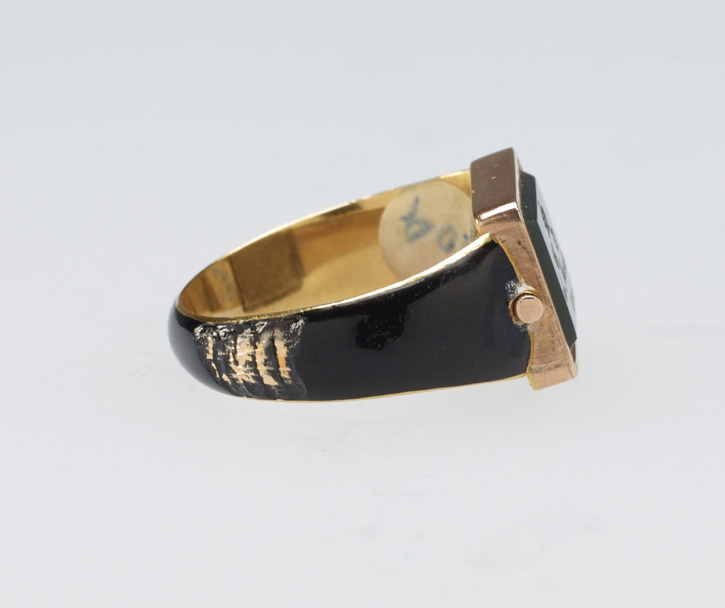 Mourning ring for Georgiana, Duchess of Devonshire (1757-1806). Gold ring, hoop enamelled in black with central hinged rectangular reserve, set with bloodstone carved with ducal coronet above gothic GD monogram and inscription, 'ob. March 30 / 1806'. Back set with woven hair behind glass.