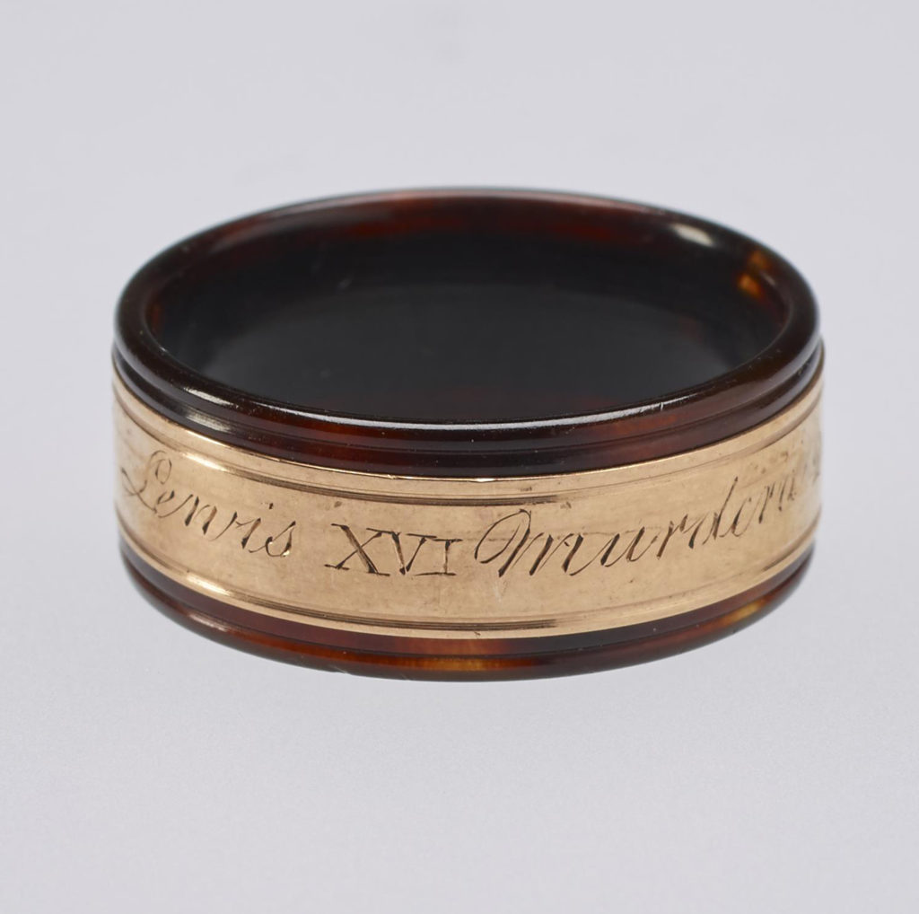 A tortoiseshell and rose gold mourning ring. Reeded tortoiseshell set with central gold band engraved with memorial inscription. In memory of Louis XVI.