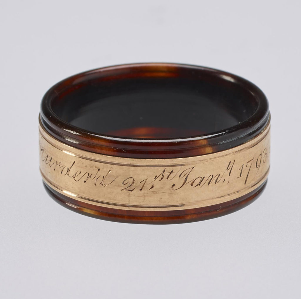 A tortoiseshell and rose gold mourning ring. Reeded tortoiseshell set with central gold band engraved with memorial inscription. In memory of Louis XVI.