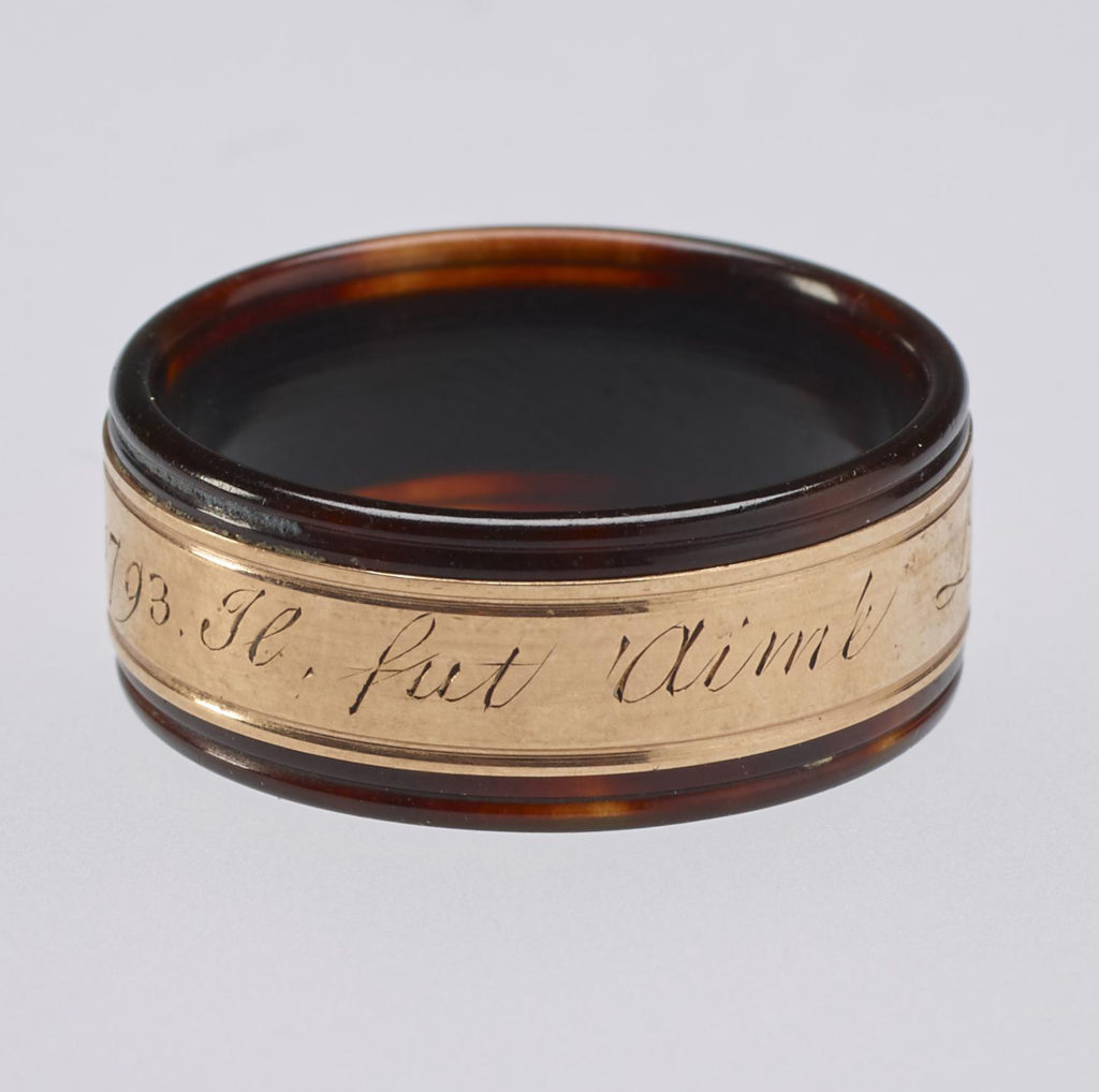 A tortoiseshell and rose gold mourning ring. Reeded tortoiseshell set with central gold band engraved with memorial inscription. In memory of Louis XVI.