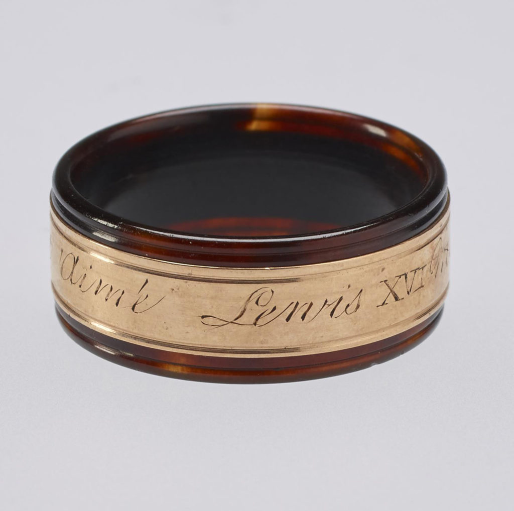 A tortoiseshell and rose gold mourning ring. Reeded tortoiseshell set with central gold band engraved with memorial inscription. In memory of Louis XVI.