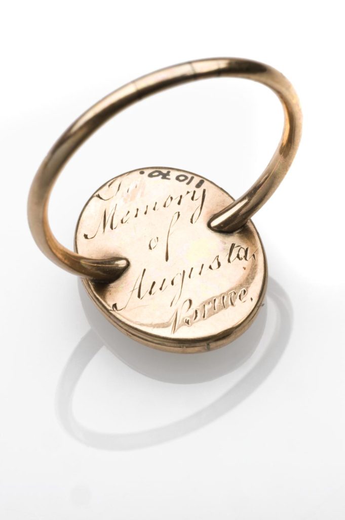 Gold memento mori ring, with oval setting which shows a flower and an inscription painted on a white background, beneath glass, possibly, glass, possibly 18th century. Full view of back of ring showing inscription. White background. Wellcome collection at the Science Museum.
