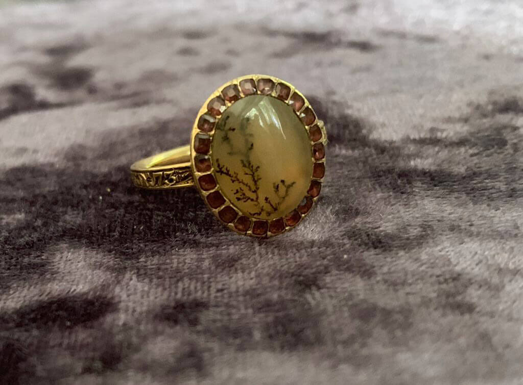 Moss agate mourning ring surrounded with garnets. Dedicated to Magdalen Bayley, Oct. 1774 Aged 73.