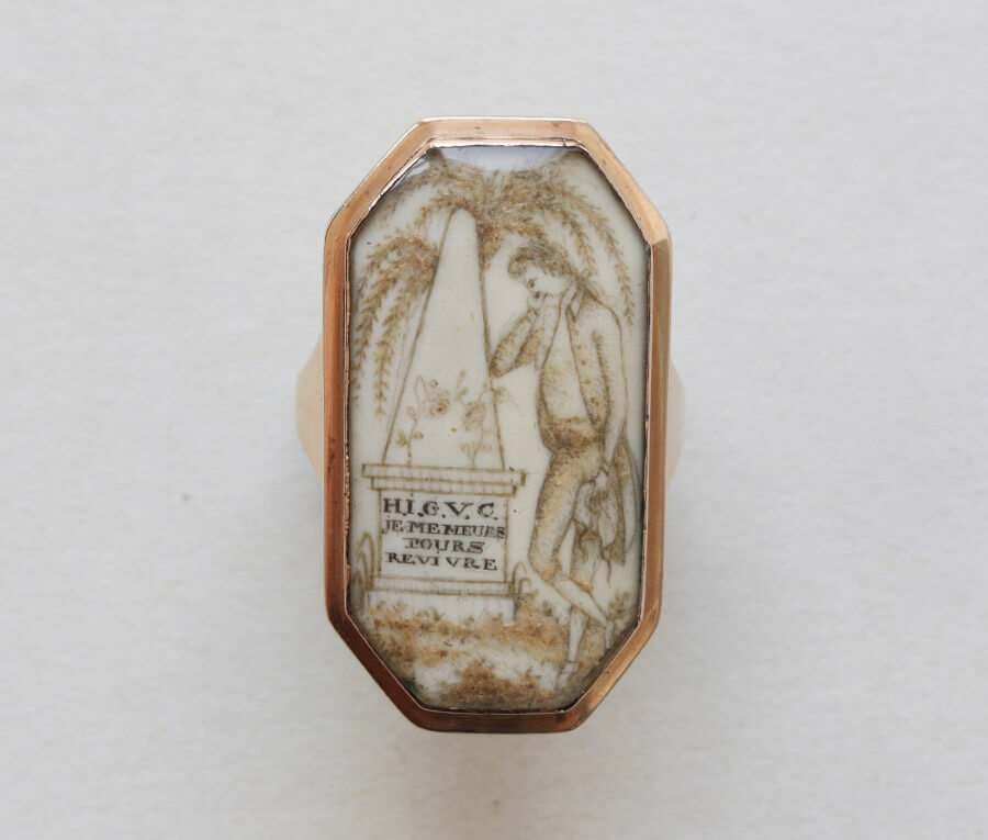 Octagonal male mourning ring painted in sepia on ivory. Neoclassical scenario shows tomb and willow. French, c.1780.