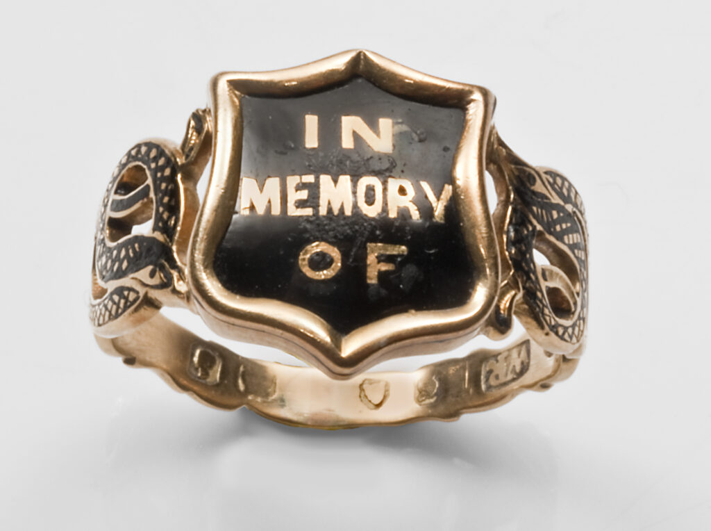A sister mourning ring reading 'IN MEMORY OF' for Mary Ann Lewis who died in 1853. Her hair is underneath the bezel in a glass compartment.