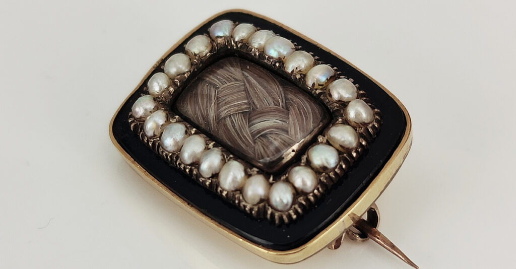 c.1850 mourning brooch with black enamel, human hair and pearl. Courtesy Kalmar Antiques.