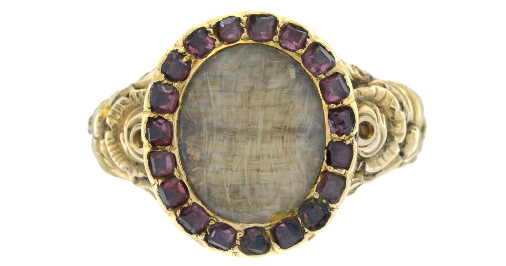 c.1820 George III mourning ring showing woven hair and garnets. Auctioned by Fellows in 2022.