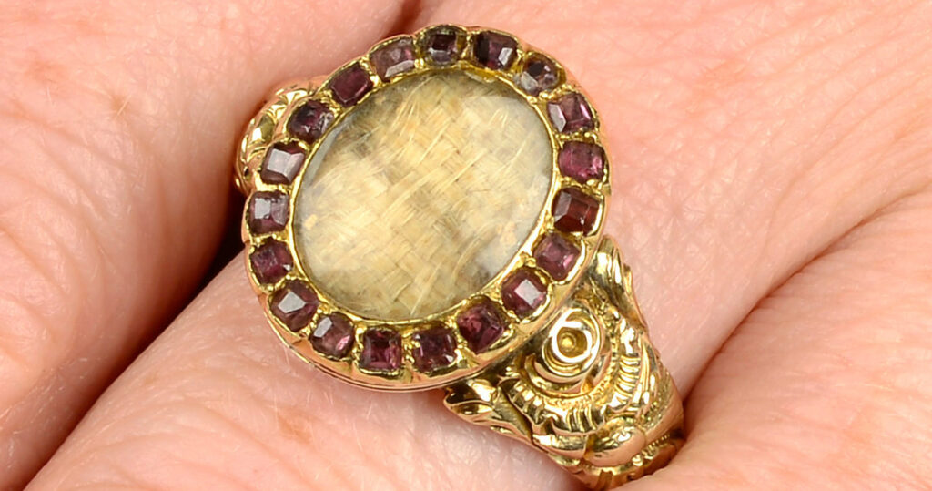 c.1820 George III mourning ring showing woven hair and garnets. Sold through Fellows Auctions in 2022.