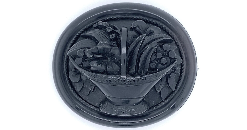 Forget me nots, daisies, myrtle in a basket made from Whityby Jet courtesy of the Whitby Jet Museum